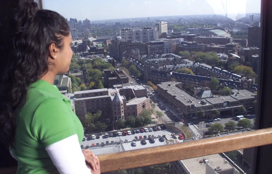 A young woman looks at the Quad and Stouffer from one of the high-rise rooftop lounge windows